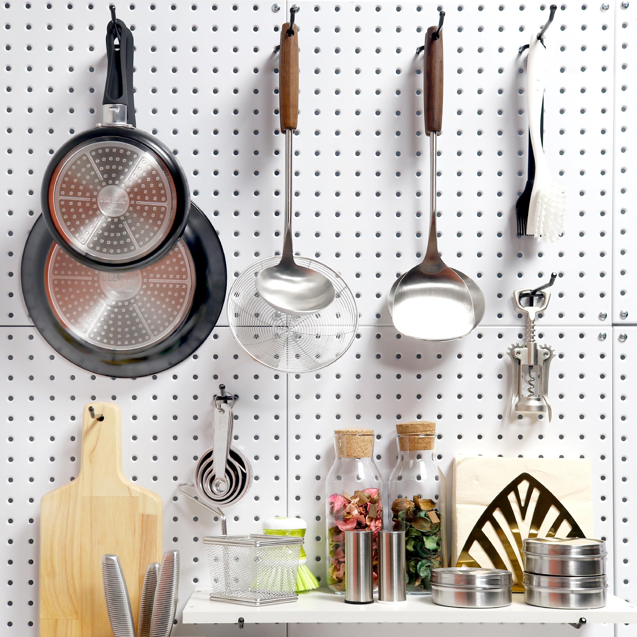 This image depicts a Huhole pegboard storage system being utilized in a kitchen setting. The pegboard is neatly arranged with various kitchen tools and accessories, such as pots, pans, utensils, and jars, all organized and easily accessible. 